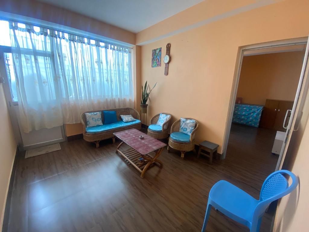 uma sala de estar com um sofá, cadeiras e uma mesa em Ritesh BNB em Gangtok