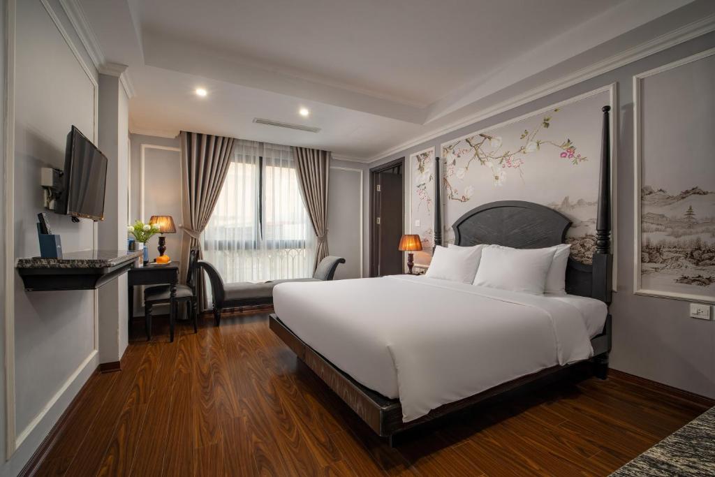 Amara Hanoi Hotel في هانوي: غرفة نوم مع سرير أبيض كبير ومكتب