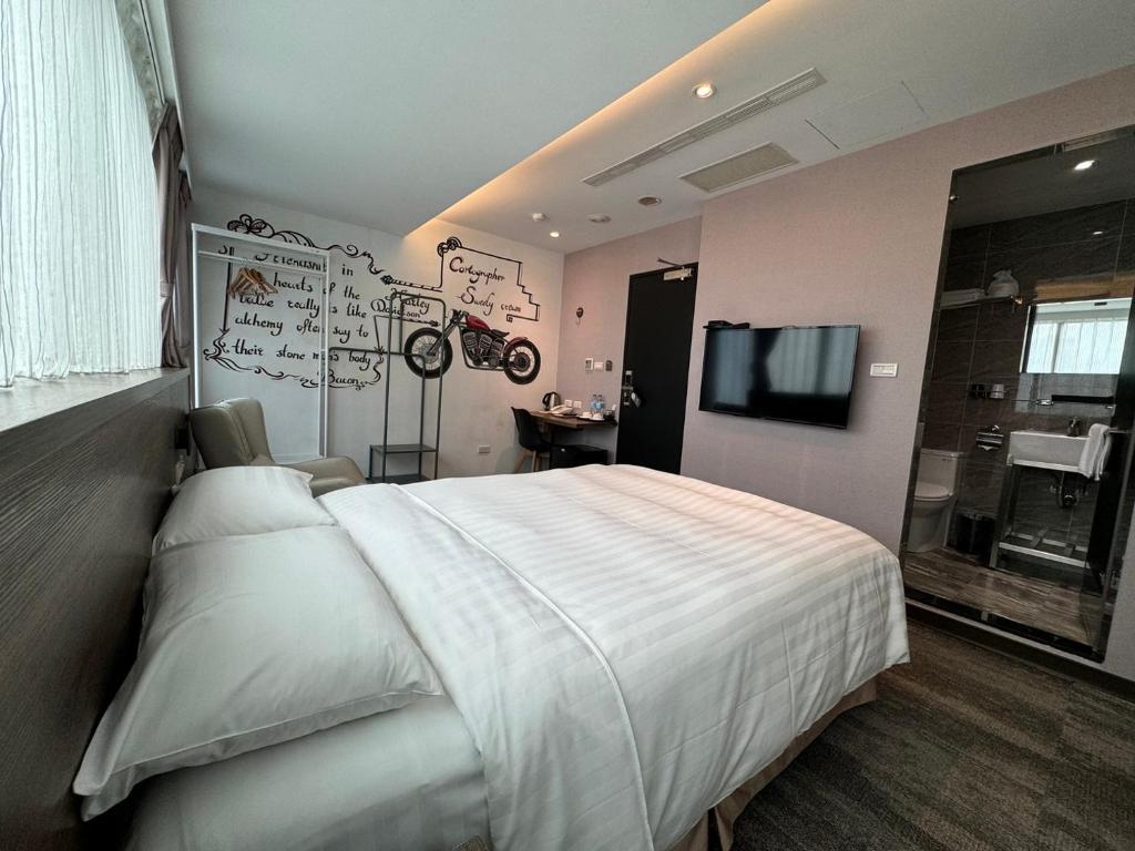 1 dormitorio con 1 cama blanca grande y TV en RF Hotel – Linsen, en Taipéi