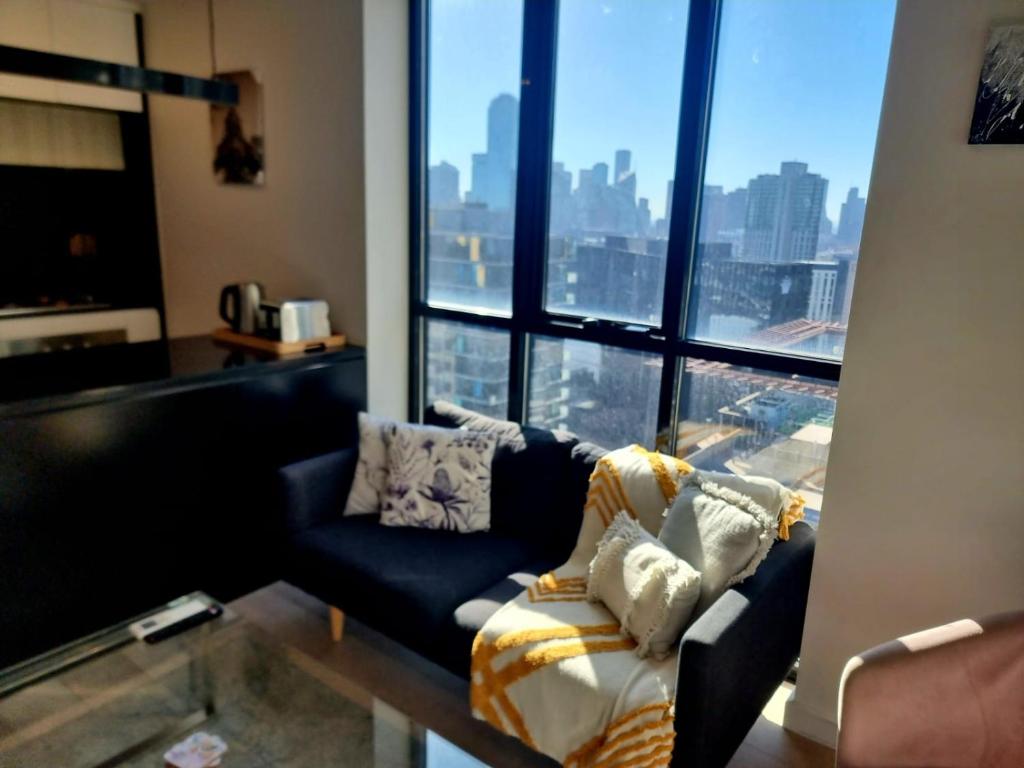 a living room with a couch and a large window at High Rise Unit in front of Crown with Free Parking in Melbourne