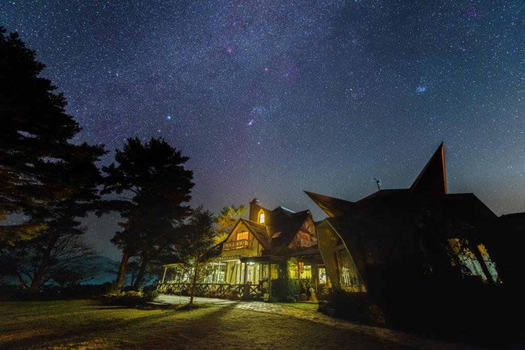ein Haus unter einem Sternenhimmel in der Nacht in der Unterkunft Minami Aso Luna Observatory Auberge Mori no Atelier in Minami Aso