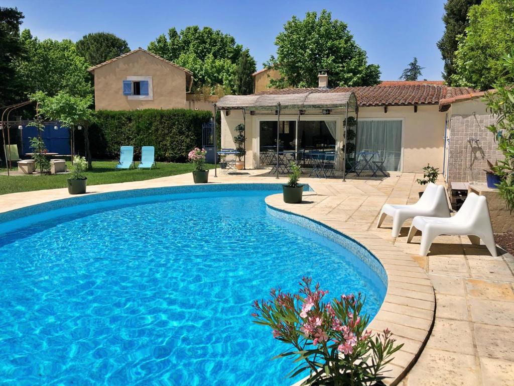 - une piscine dans une cour avec des chaises et une maison dans l'établissement Clos St Pierre de Fraisse, à Montfavet