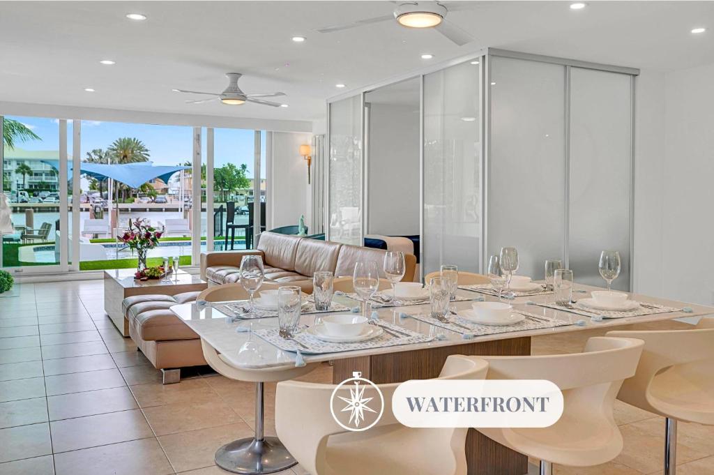 un comedor con una mesa con copas de vino. en Suite by Beach Waterfront Lago Key Three, en Fort Lauderdale