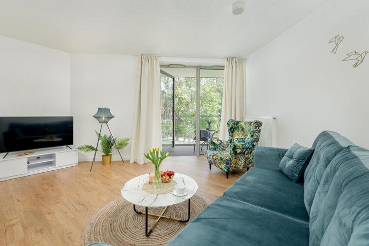 a living room with a blue couch and a table at Apartment in Pobierowo near Baltic Beach in Pobierowo