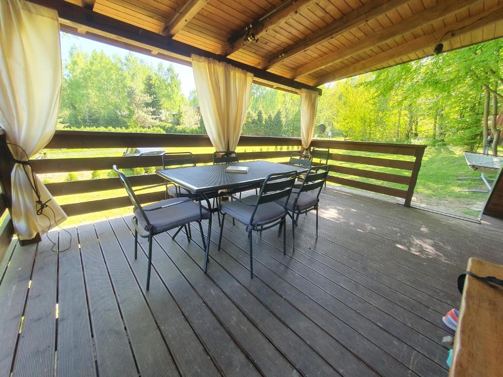 a patio with a table and chairs on a deck at RESET W WERLASIE- Domek na wyłączność- kajak w cenie in Werlas