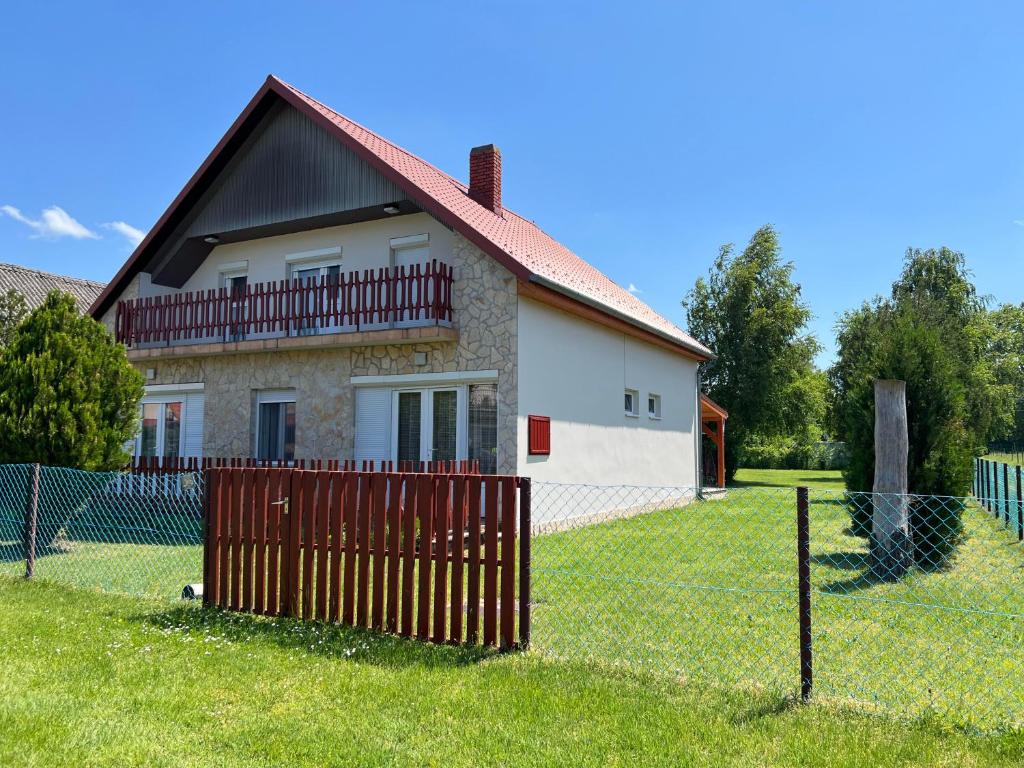 a house with a fence in front of it at Lukács nyaralóház in Balatonfenyves