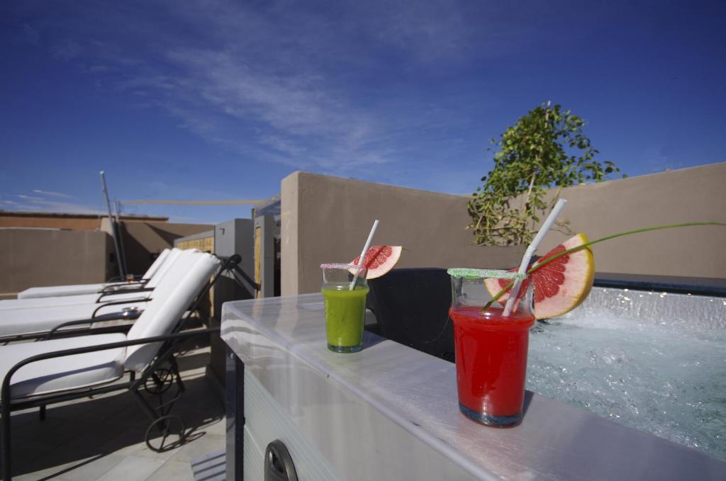 two drinks sitting on a ledge on a balcony at Riad Kasbah 117 in Marrakesh