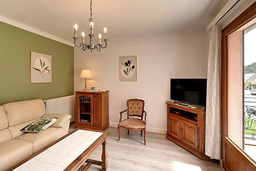 a living room with a couch and a tv at Vert Olive - Maison proche Sélestat Colmar in Rombach-le-Franc