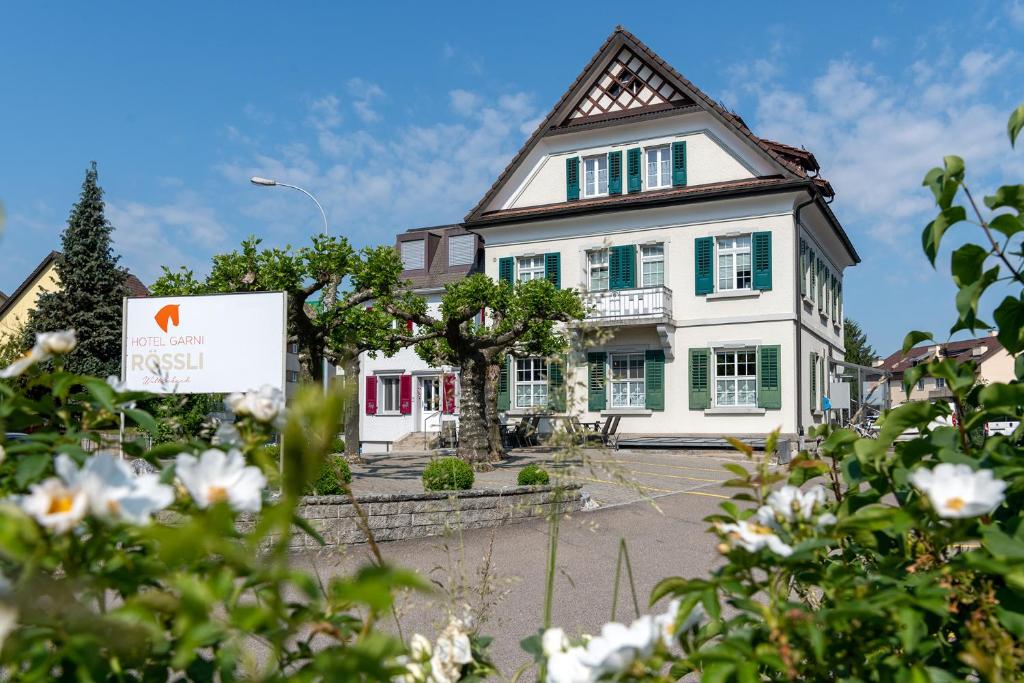 une maison avec un panneau devant elle dans l'établissement Hotel Garni Rössli, à Saint-Gall