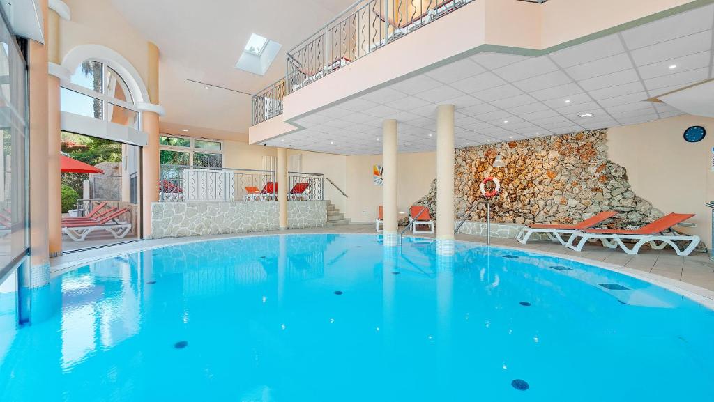a large swimming pool in a hotel room with a large swimming pool at Résidence les Tourelles in Sainte-Maxime