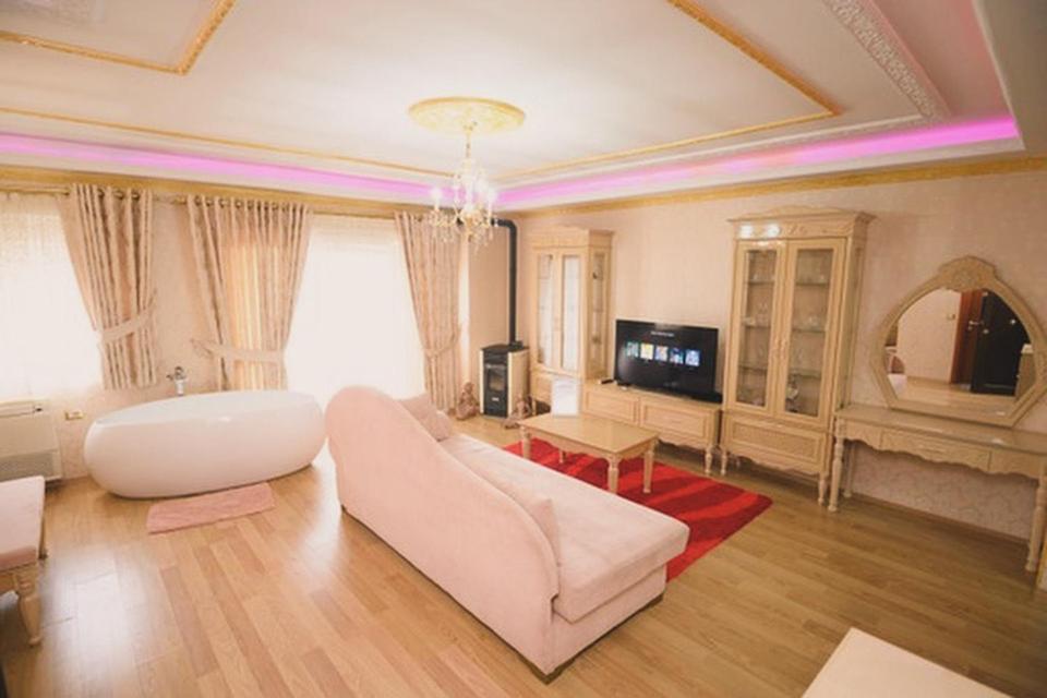 a living room with a white couch and a tv at Luxurious Apartment Lake View Pogradec in Pogradec
