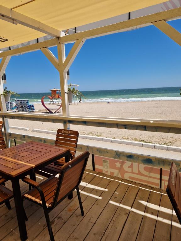 een tafel en stoelen op een terras met het strand bij Vila Karina Beachfront Vama Veche in Vama Veche
