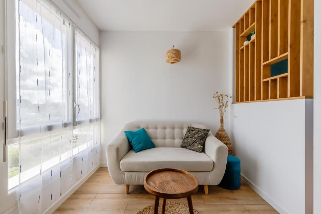 un salon avec un canapé et une fenêtre dans l'établissement L'estacade - charmant studio proche de la mer, à Saint-Jean-de-Monts