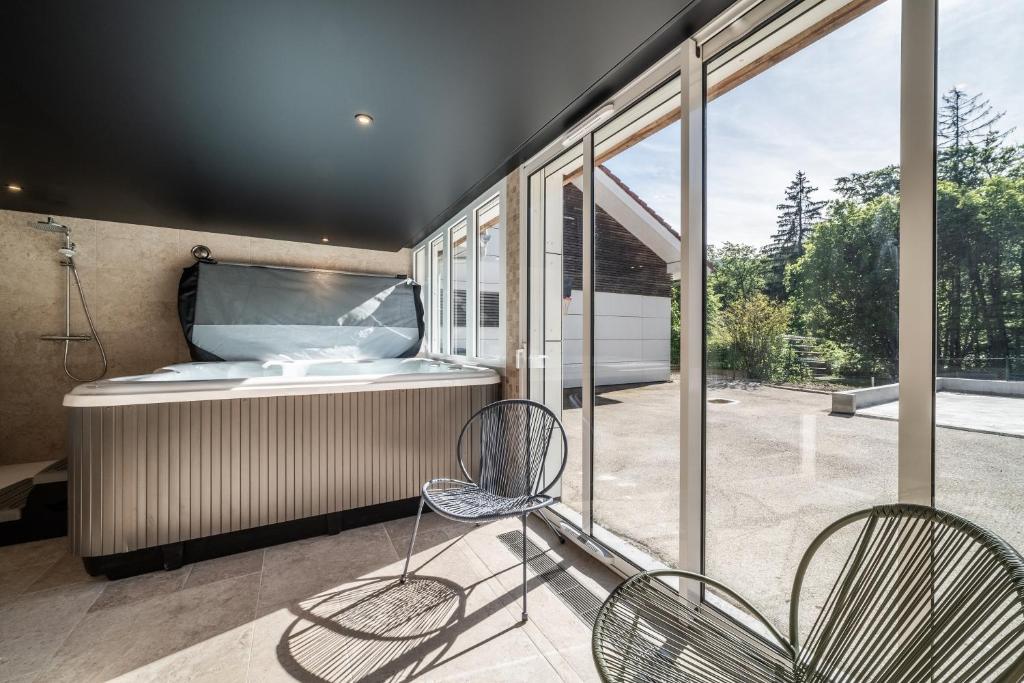 La salle de bains est pourvue d'une baignoire et de 2 chaises. dans l'établissement Ô songes de Saxel, à Saxel