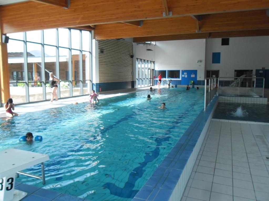 un groupe de personnes nageant dans une piscine dans l'établissement Village Vacances Passion Le Cezallier, à Ardes-sur-Couze