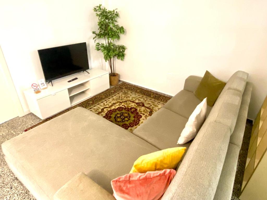 uma sala de estar com um sofá e uma televisão de ecrã plano em Apartamento Padrón Centro, Camino De Santiago P2 UR em Padrón