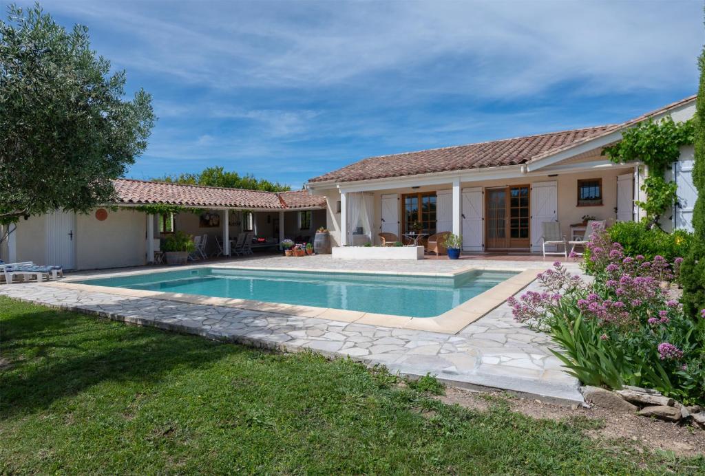 a house with a swimming pool in a yard at Le Bariole, luxury villa with heated pool in Cesseras