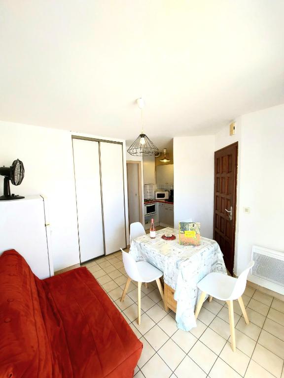 un salon avec une table, des chaises et un canapé dans l'établissement soleil catalan 150m mer ok chéques vacances animaux 1ere étage 4pers wifi parking, à Saint-Cyprien