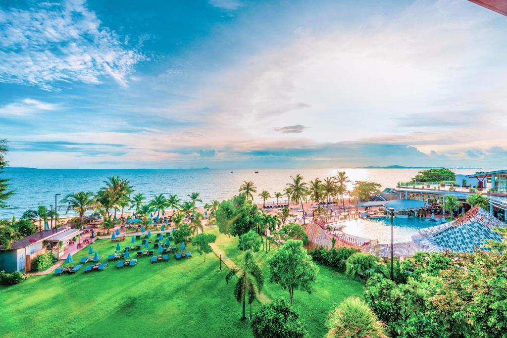 Pinnacle Grand Jomtien Resort and Beach Club - SHA Extra Plus في نا جومتين: اطلالة جوية على منتجع مع مسبح و المحيط