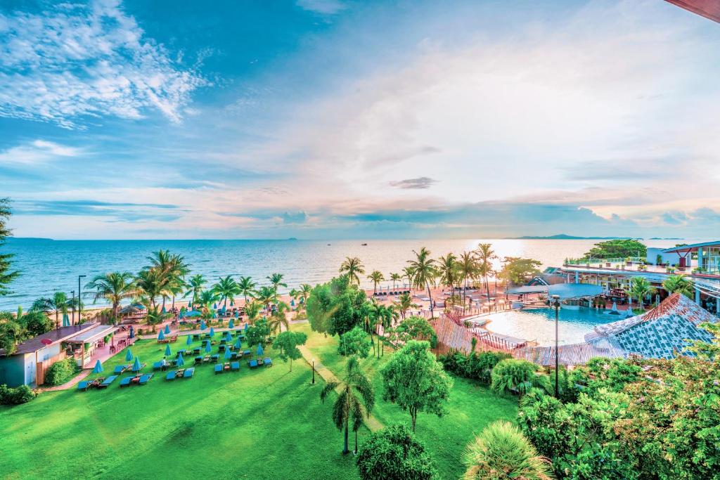 an aerial view of a resort with a pool and the ocean at Pinnacle Grand Jomtien Resort and Beach Club in Na Jomtien