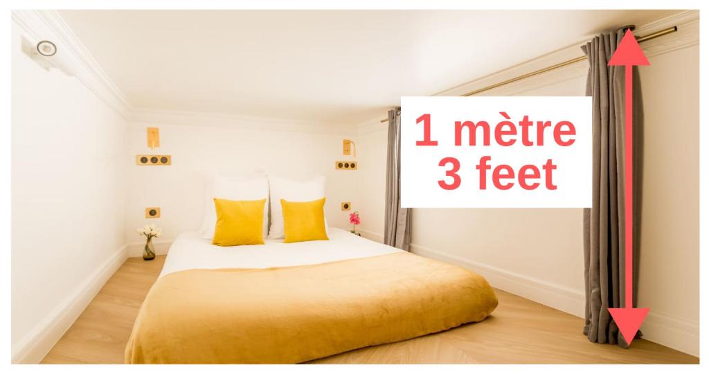 ein Schlafzimmer mit einem Bett mit einem Meter-Fuß-Schild in der Unterkunft Luxury 4 bedroom 4 bathroom Apartment - Louvre in Paris