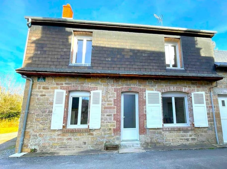 une maison en briques avec des fenêtres blanches et un toit dans l'établissement Belle Maison à Tarnac Corrèze, à Tarnac