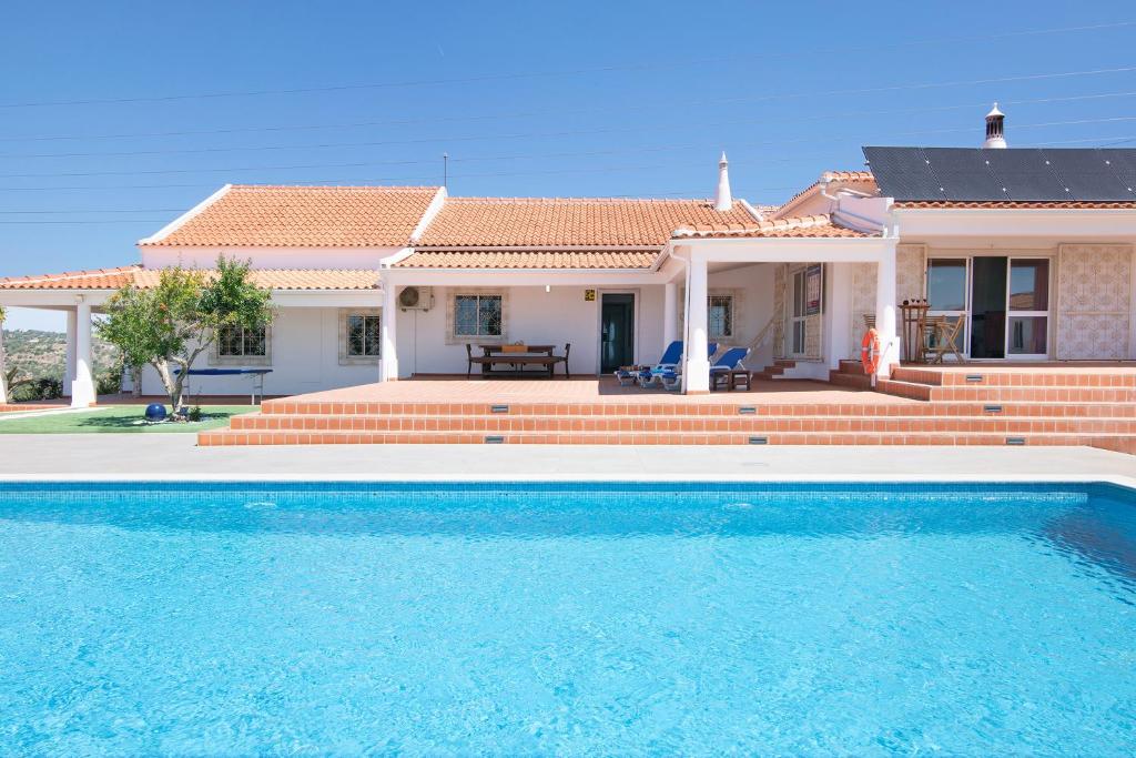 uma villa com piscina em frente a uma casa em Monte do Pataco em Albufeira