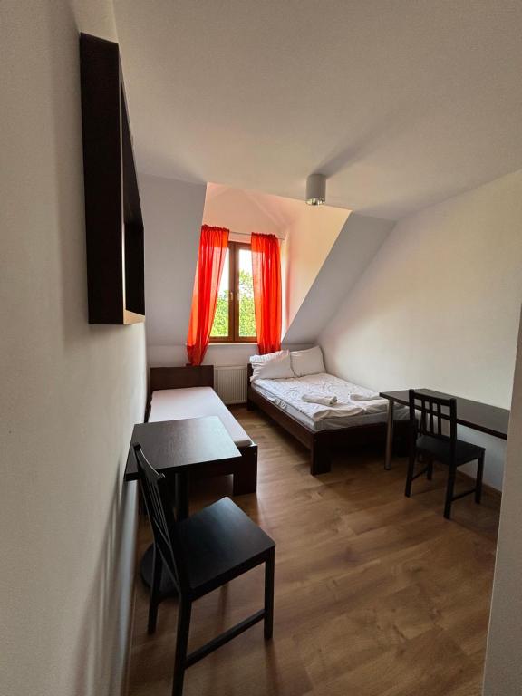 a small room with a bed and a table and chairs at WILLA ELITA in Krynica Morska