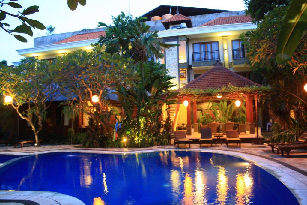 a swimming pool in front of a house at Jepun Bali Hotel in Kuta