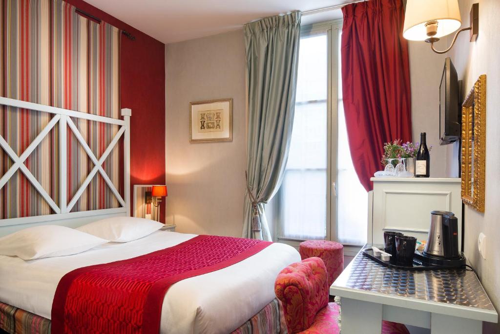 una camera d'albergo con letto e finestra di Hotel Louvre Bons Enfants a Parigi