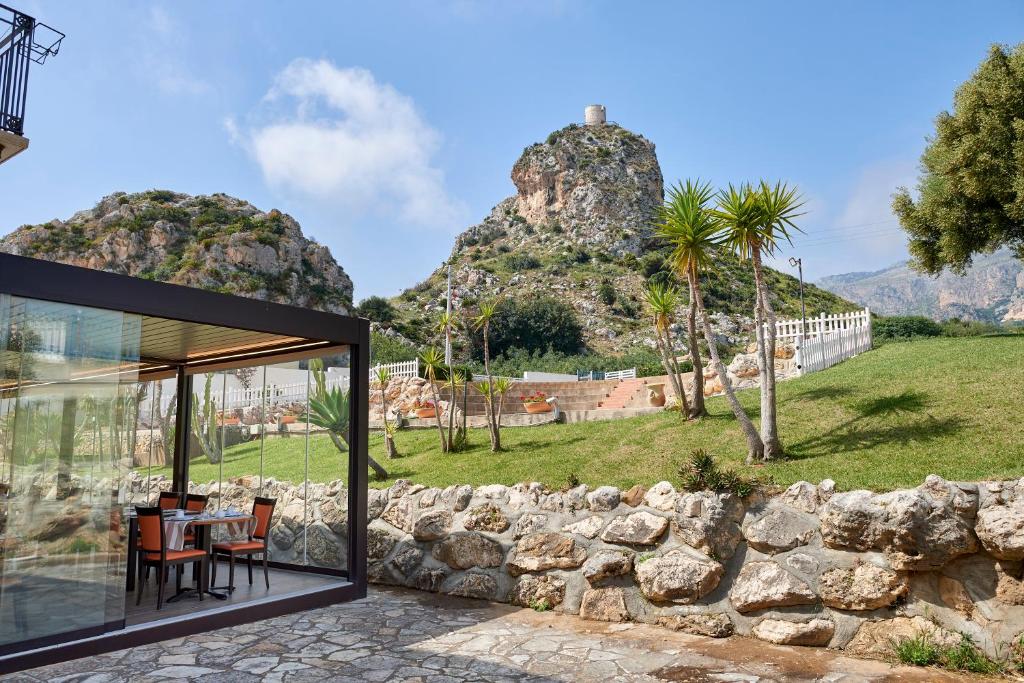 a house with a view of a stone wall at Baglio Dello Zingaro in Scopello