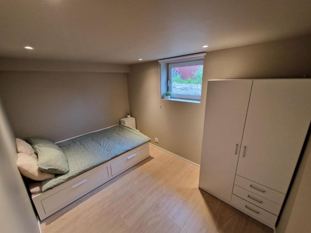 Habitación pequeña con cama y ventana en Apartment in the city, en Porsgrunn