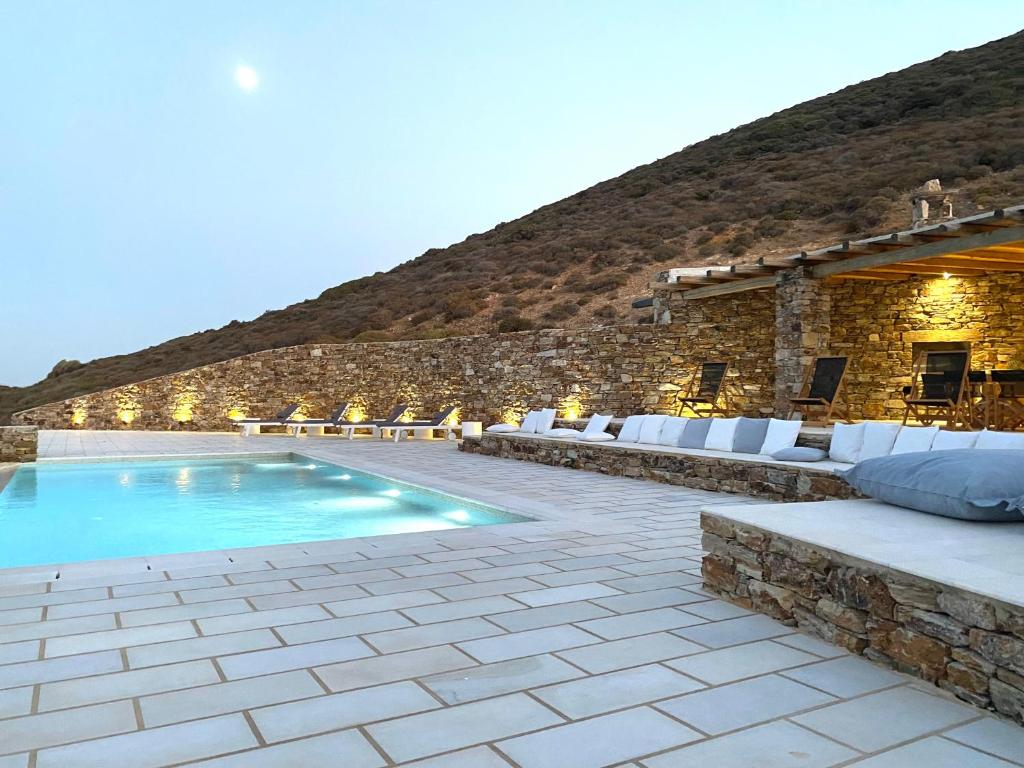 a swimming pool with lounge chairs next to a building at Villa Artemis in Agios Georgios