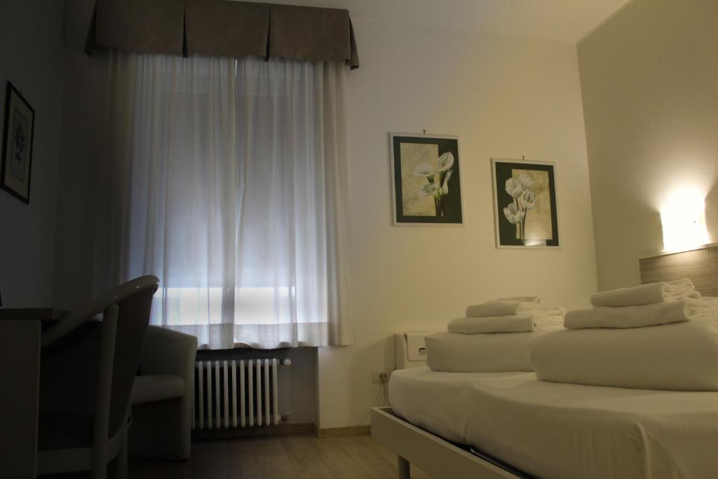 ein Hotelzimmer mit 2 Betten und einem Fenster in der Unterkunft Hotel Roma in Palmanova