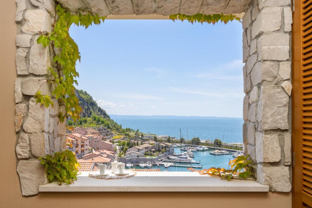 a window with a view of a harbor at Portopiccolo Apartments in Sistiana