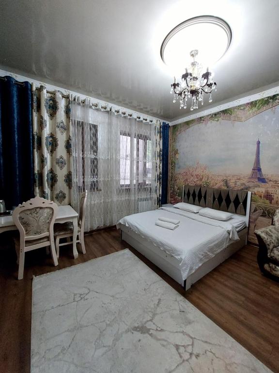 a bedroom with a bed and a chandelier at Camelot hotel in Bishkek