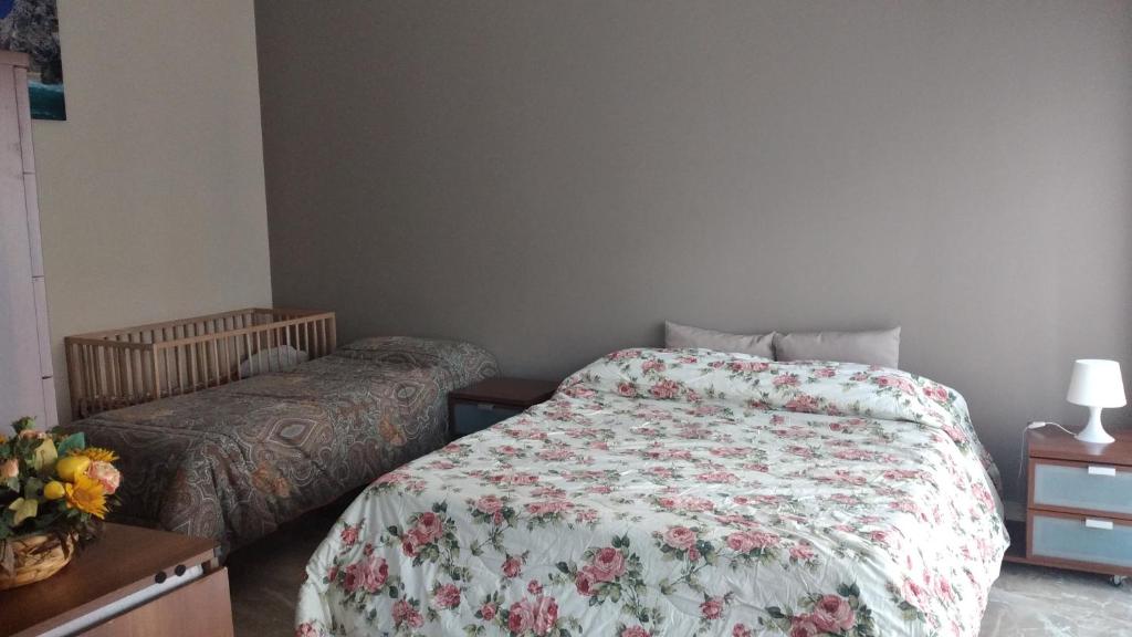 a bedroom with a bed with a floral comforter at Arcobaleno in Stazione in Saronno