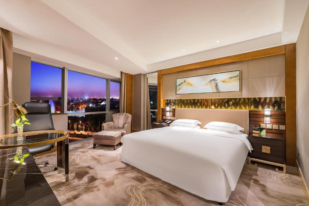 1 dormitorio con 1 cama blanca grande y escritorio en Lake View Hotel, en Beijing