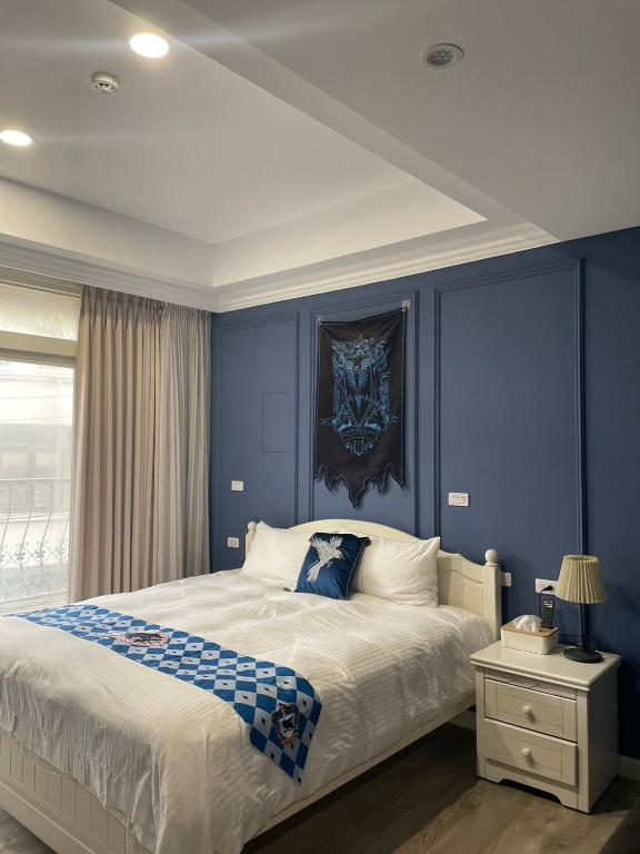 ein Schlafzimmer mit blauen Wänden und einem großen Bett in der Unterkunft 鹿莫思 Lumos in Qingshui