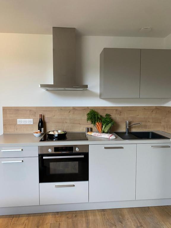 a white kitchen with a sink and a stove at Plein Centre Bastia in Bastia