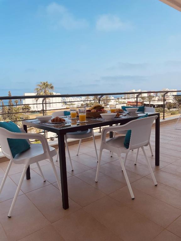 a table and chairs on a balcony with a view of the ocean at Fig Tree View Apartments in Protaras