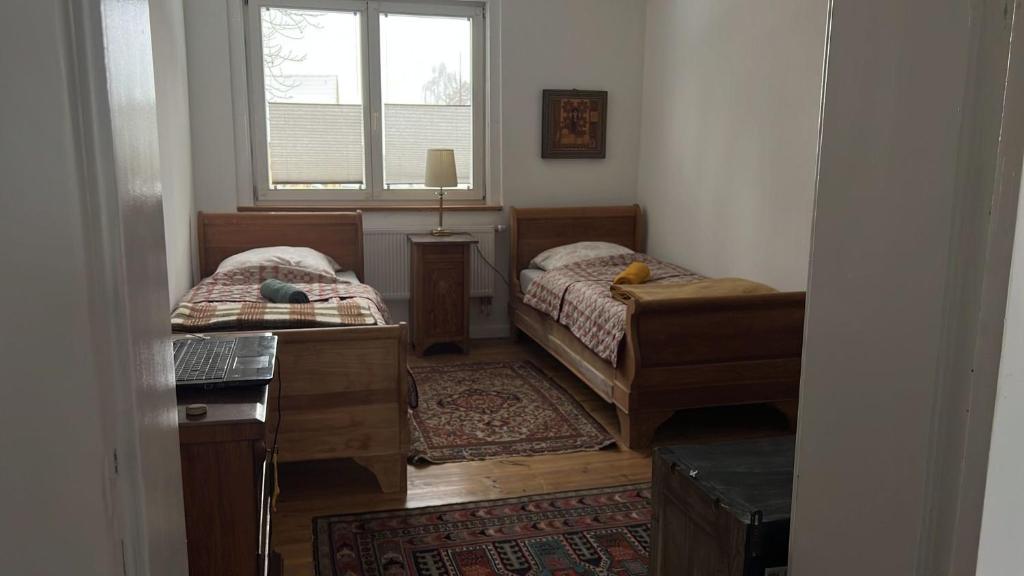 a room with two beds and a window at Antike Wohnmöglichkeit kurz und Langfristig 100qm 1 Stock in Lauchhammer