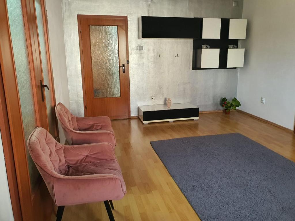 a living room with two chairs and a table at Apartament 2 camere cazare in Zalău