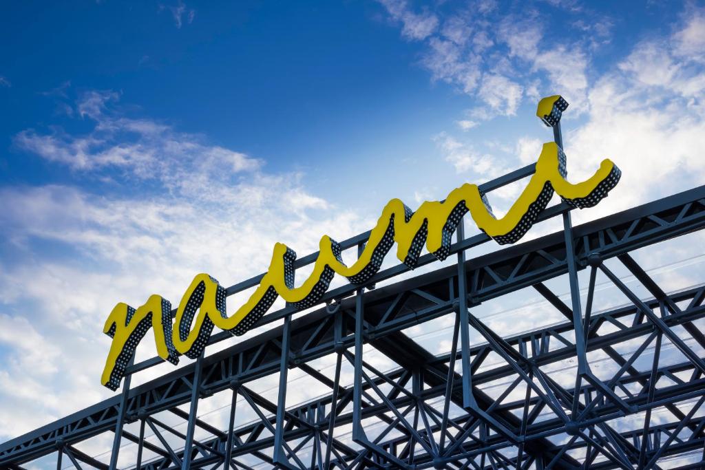 a large yellow sign on top of a metal structure at Naumi Auckland Airport Hotel in Auckland