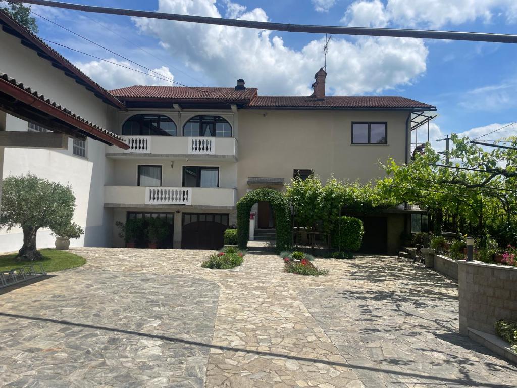 a large white house with a driveway at Apartma pri Cesarjevih in Sežana
