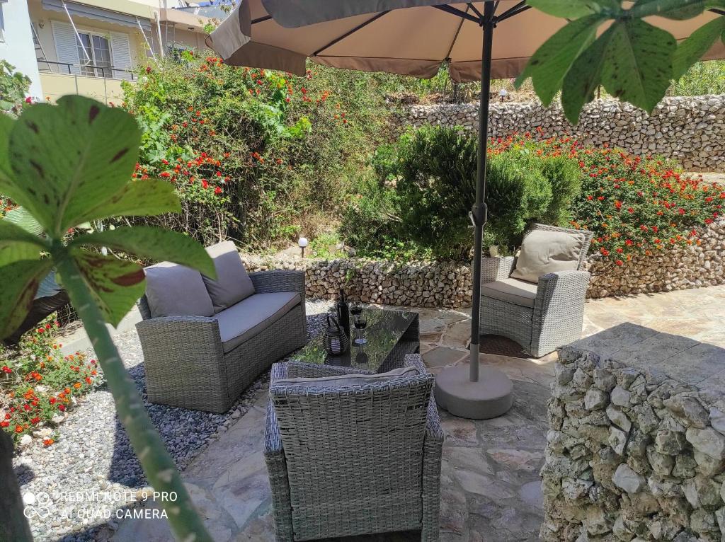 patio z krzesłami i stołem z parasolem w obiekcie lila's city house w mieście Rodos