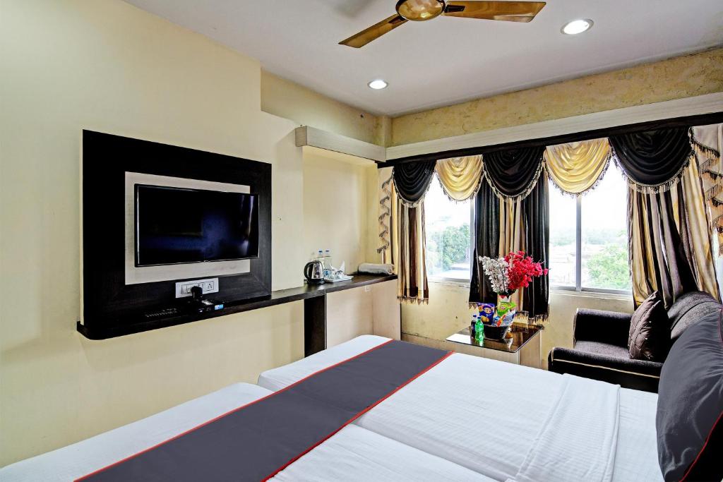 1 dormitorio con 1 cama y TV de pantalla plana en OYO Flagship Hotel Night Owl, en Durgāpur