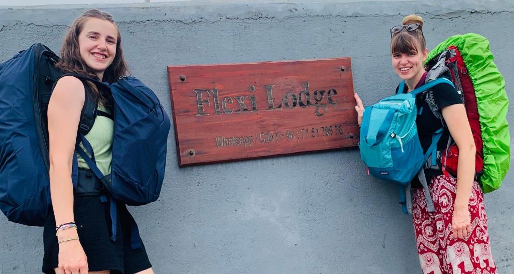deux filles debout devant un panneau dans l'établissement Flexi Lodge, à Negombo