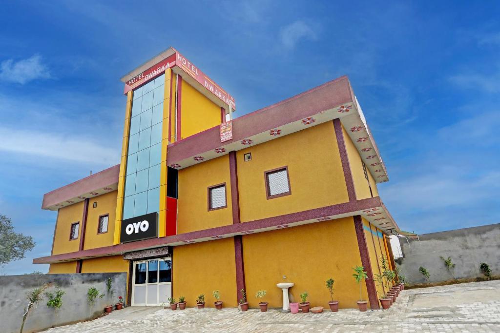 um edifício amarelo com um sinal de om em Hotel Dwarka em Alīgarh