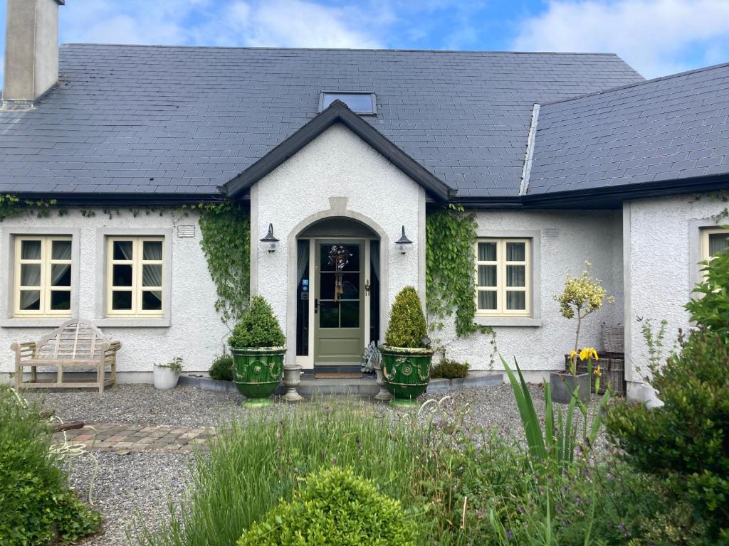 una casa blanca con una puerta verde en Ballybur Lodge, en Grange